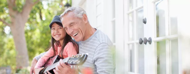Grandpa play guitar with grandaughter